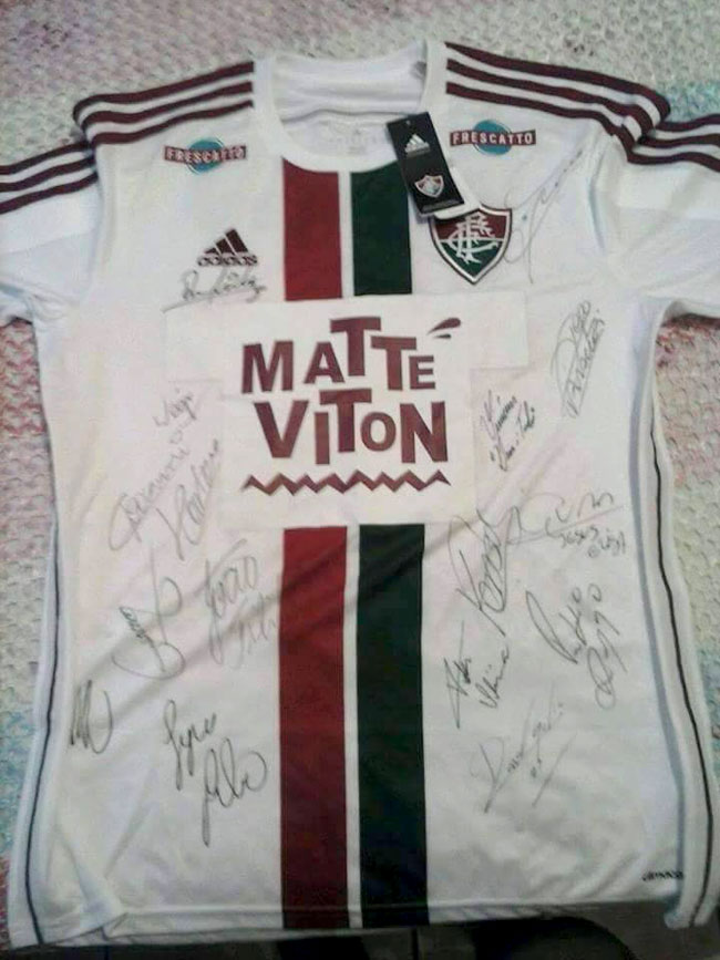 Família arrecada metade do valor para tratamento na Tailândia 2 Militar de Juiz de Fora conseguiu camisa autografada pelo elenco do Fluminense; uniforme será leiloado pela família de Victor (Foto: Divulgação)