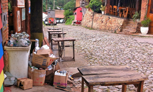 Após a saída dos turistas, vila acumula lixo  (Foto: Marciano Júnior)