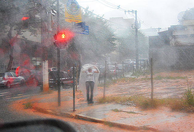 Chuva forte pode continuar nessa sexta-feira 1 Mulher tenta se proteger da chuva na esquina da Avenida Presidente Itamar Franco com Rua Antônio Passarela (Foto: Marcelo Ribeiro/11-02-16)