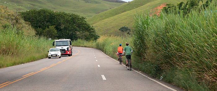 Até radares estão encobertos por mato em rodovia sem manutenção 2 Ciclistas se arriscam na estrada onde mato impede circulação nas margens da via, que tem traçado antigo e sinuoso (Foto: Fernando Priamo)