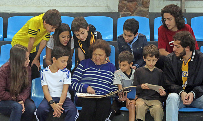 Maria Izabel Bara, esposa de Antônio Bara e mãe de Nadja, José Eduardo, Mário, Alex e Sérgio, mostra álbum com recortes da trajetória da família no esporte a netos e sobrinhos-netos (Foto: Leonardo Costa)