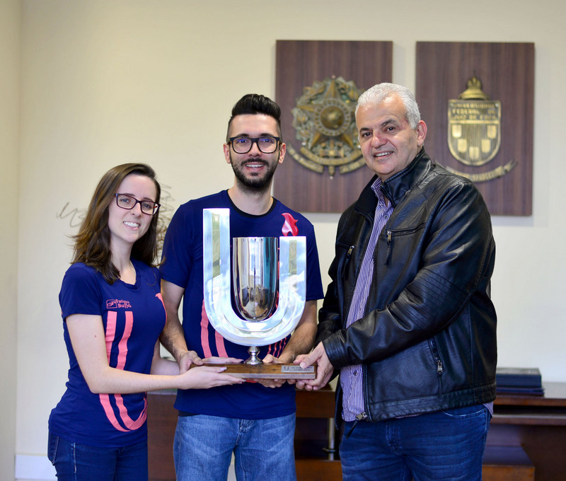Fliminas contará com a presença da jornalista Daniela Arbex 1 Os irmãos Eduarda e Basileu Gouvêa recebendo do reitor da UFJF, Marcus David, a taça de campeão geral do Universitarius, que reúne até novembro mais de 1100 atletas de 23 faculdades