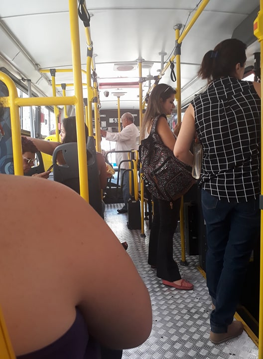 Idoso em pé em área preferencial do ônibus