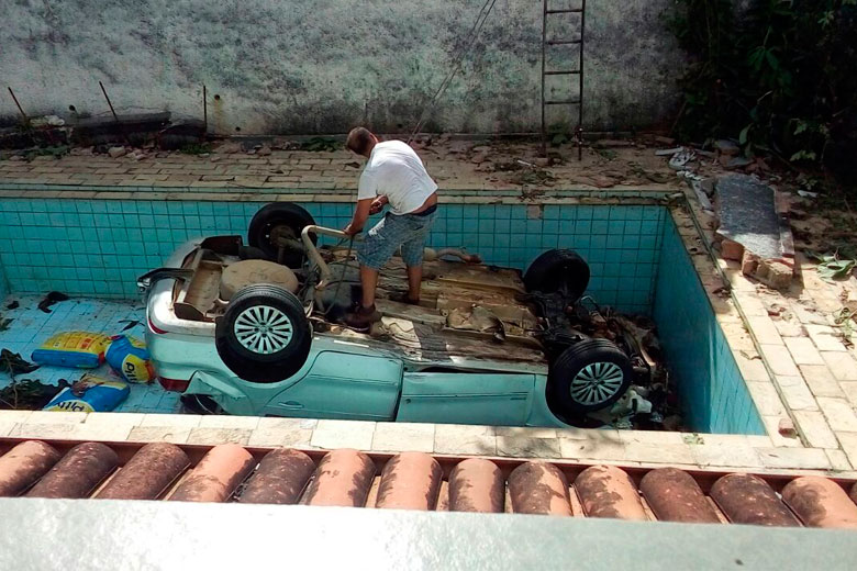 Dois funcionários trabalharam na retirada do veículo que caiu dentro de uma piscina (Foto: Leonardo Costa) Dois funcionários trabalharam na retirada do veículo que caiu dentro de uma piscina (Foto: Leonardo Costa)