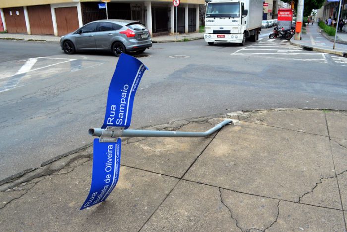 Placa caída em calçada oferece riscos a pedestres 1 VU