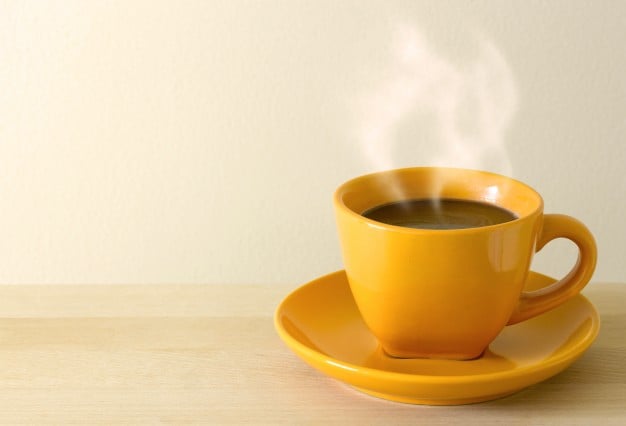 Os alimentos podem deixar os dentes amarelados? 6 copo de cafe fumegante na mesa 1373 56