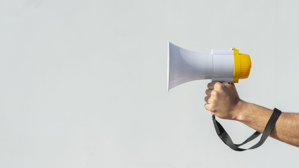 Comunicação assertiva: conheça a importância dessa habilidade para profissionais e empresas 2 hand holding megaphone protest