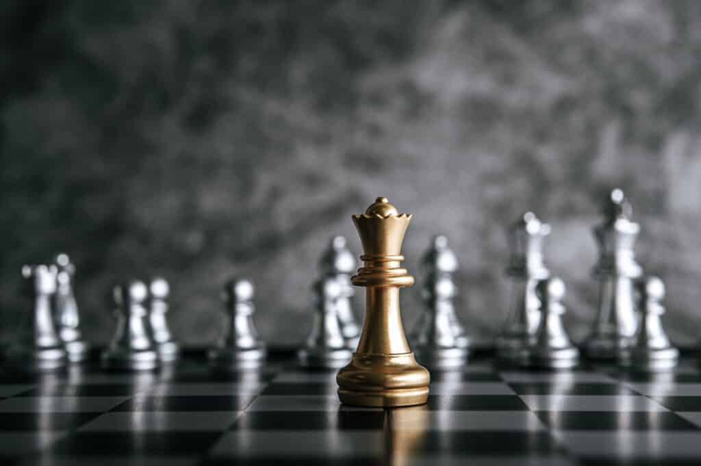 Habilidades profissionais: proatividade e tomada de decisão 2 gold and silver chess on chess board game for business metaphor leadership concept