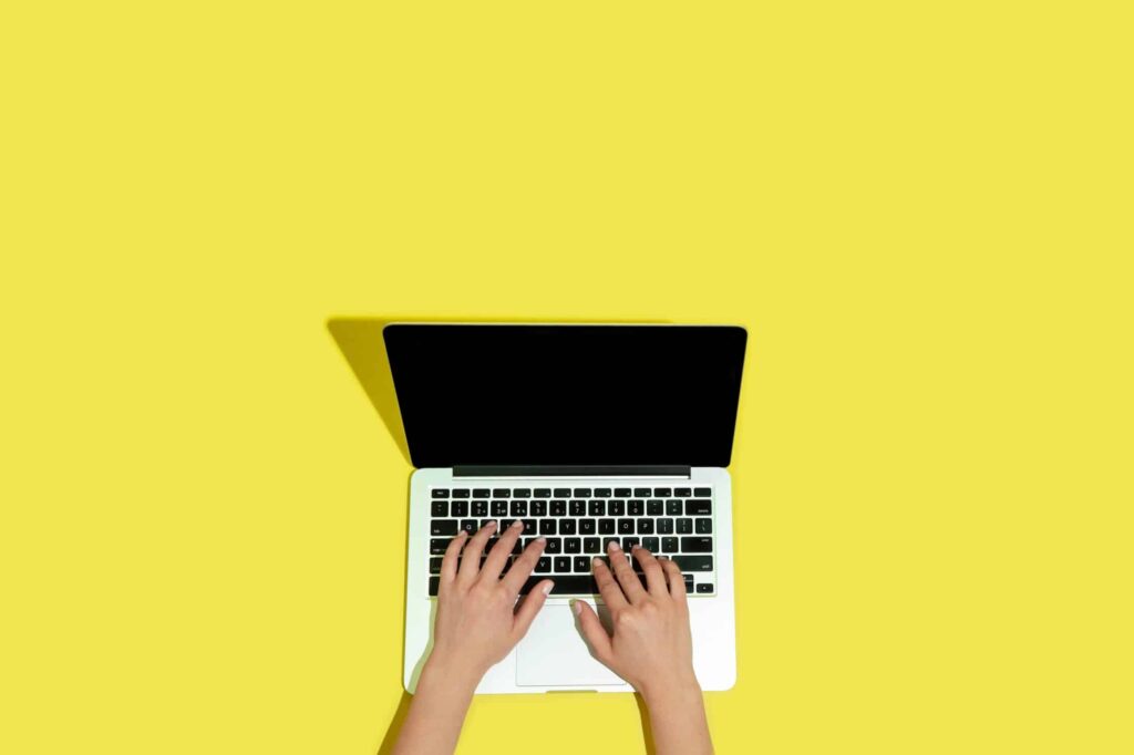 5 estratégias para economizar na criação de sites profissionais 3 hand using gadgets laptop top view blank screen scaled e1654776668371