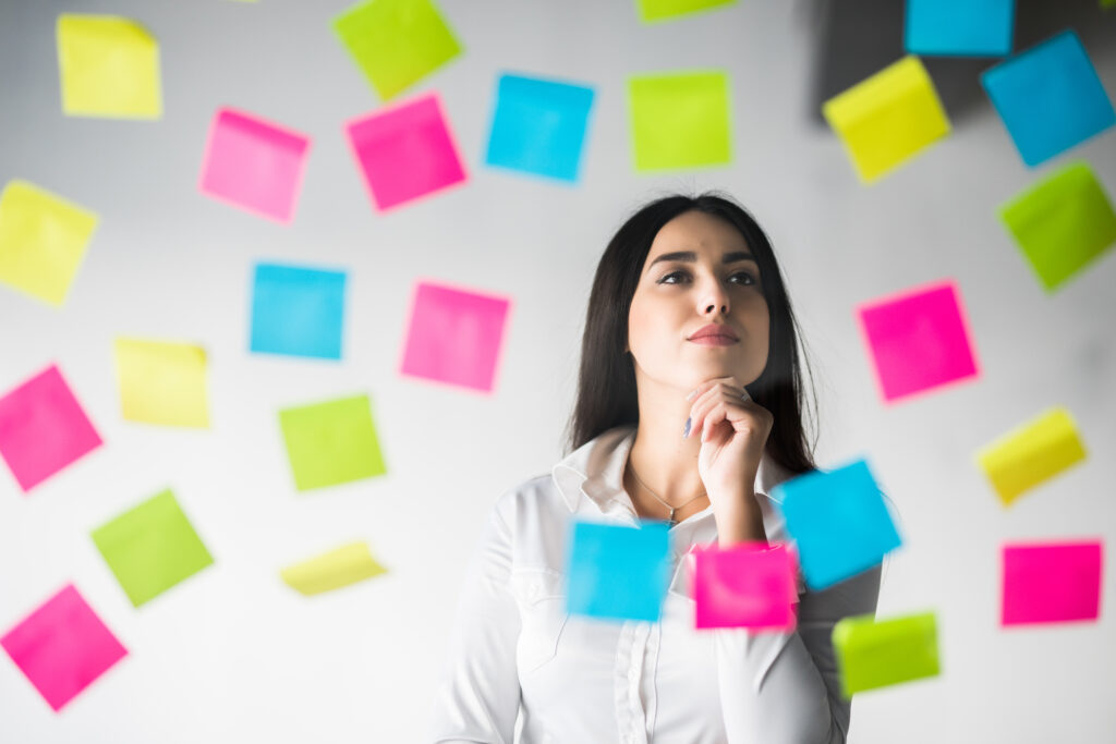 Criatividade no trabalho: por que ela pode ser a virada de chave da sua carreira 2 mulher de negocios cola adesivos e reflexoes sobre o projeto mulher planejando pensando sobre adesivos
