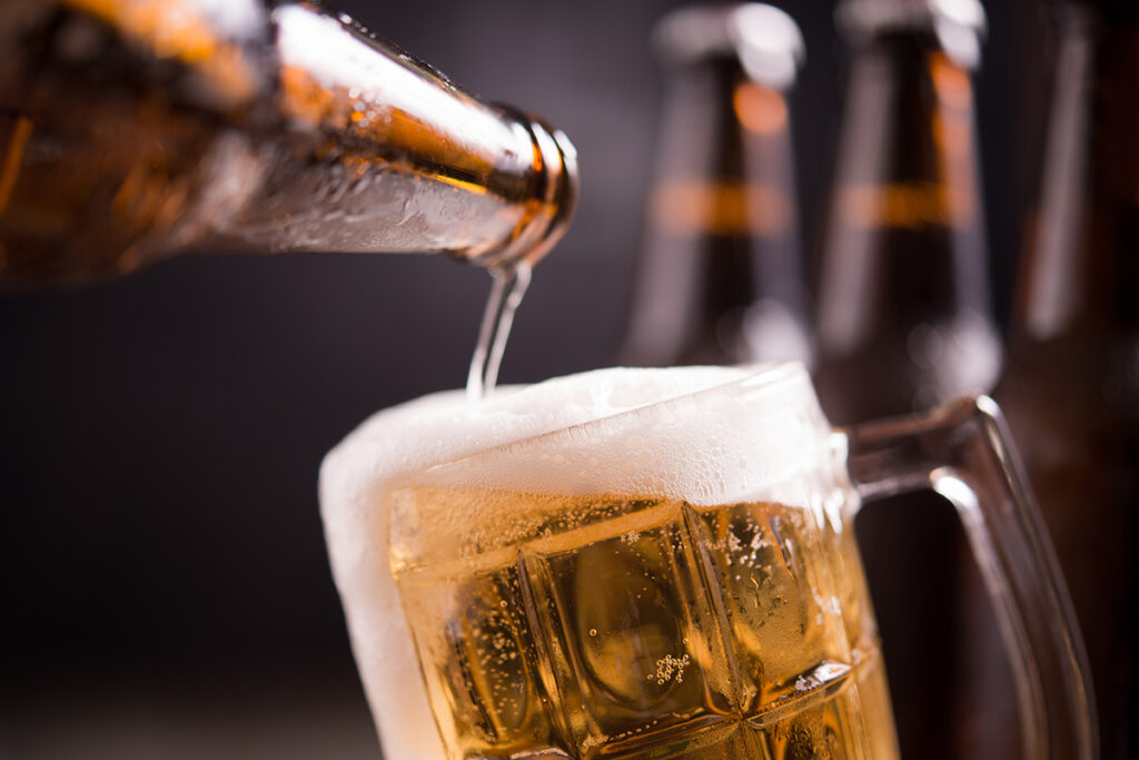 garrafas de vidro de cerveja com vidro e gelo no fundo escuro