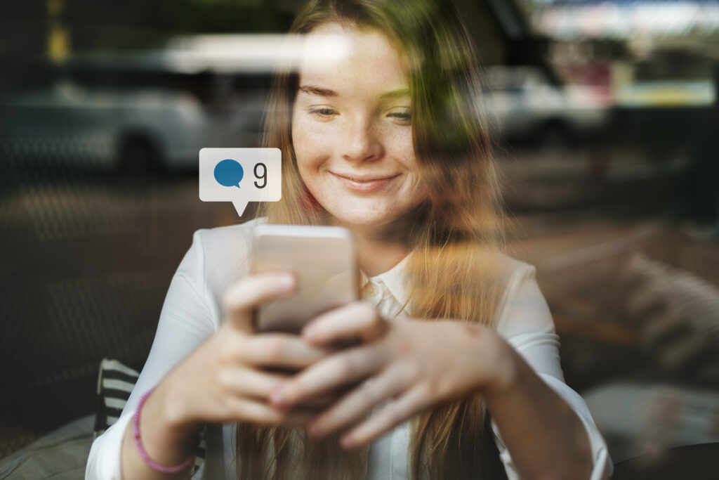 A era da reputação online: sua carreira pode ser definida pelo que você posta? 1 happy girl using social media smartphone cafe