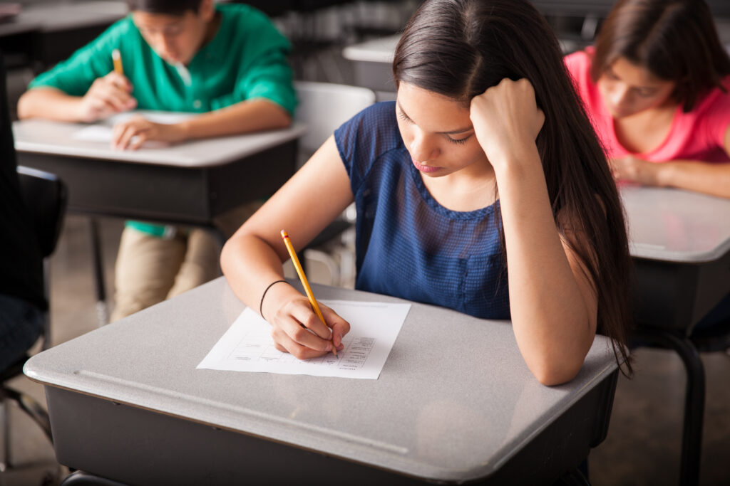 group high school students taking test classroom