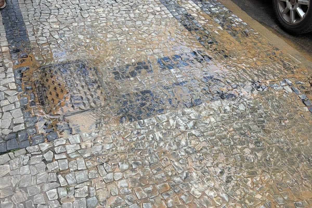 Vazamento em poço de visita suja calçada e causa transtornos no Centro