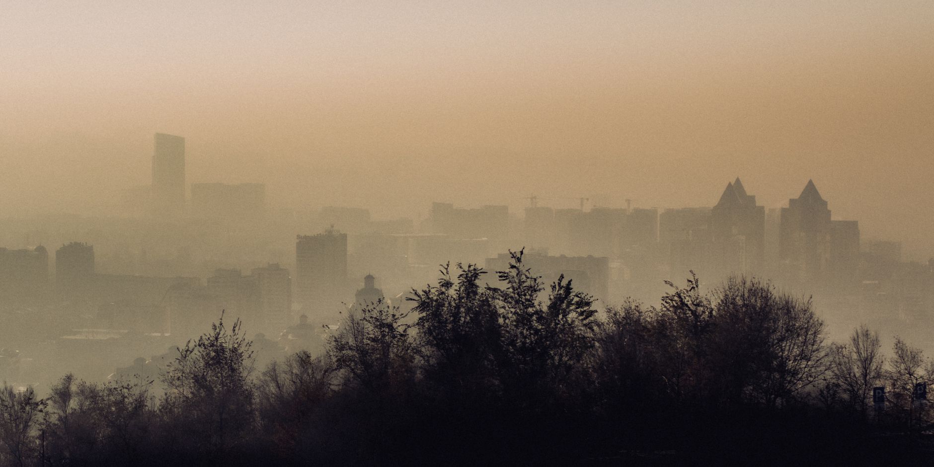Vista atmosférica do horizonte da cidade de Almaty envolta em névoa e fumaça.