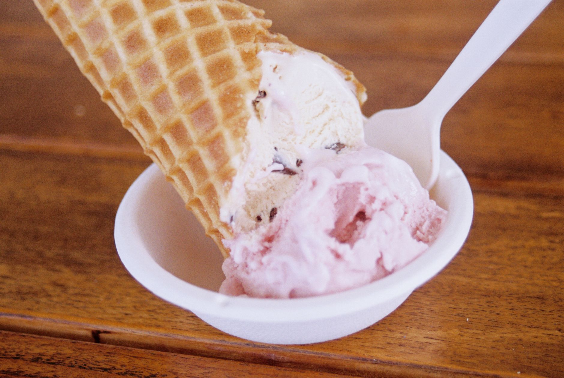 Especialistas fazem alerta sobre sobremesa que brasileiros adoram tomar quando está calor e explicam por que comer demais pode trazer consequências que vão muito além das calorias 1 Close-up de um delicioso cone de sorvete com textura de waffle em uma tigela de cerâmica sobre uma mesa de madeira.