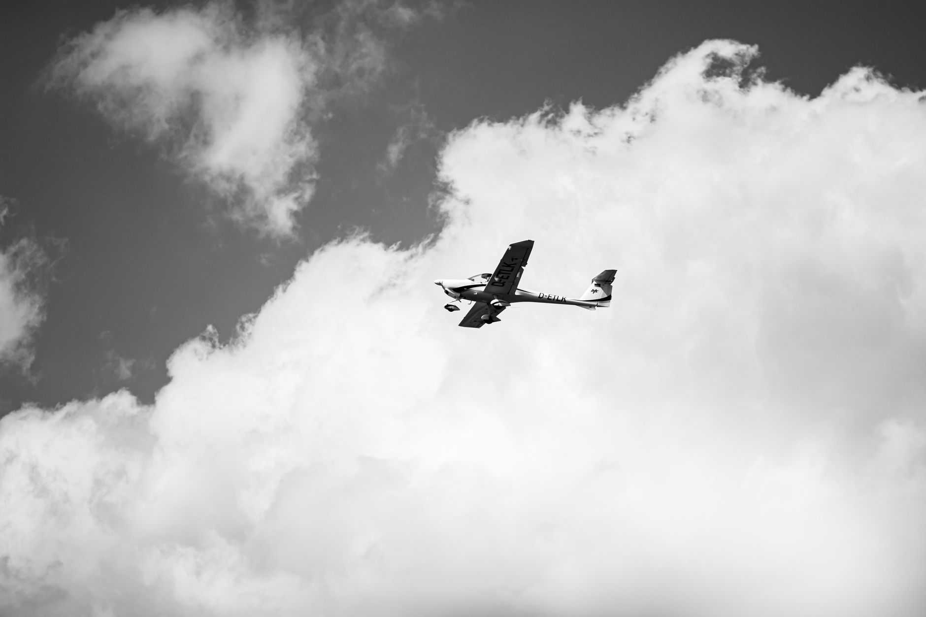 Há 46 anos, empresário e piloto desapareceram durante um voo no Brasil e nunca mais foram encontrados, transformando uma viagem comum em um dos grandes mistérios da aviação 1 Foto em preto e branco de uma aeronave leve voando acima das nuvens, capturada em Bremen, Alemanha.