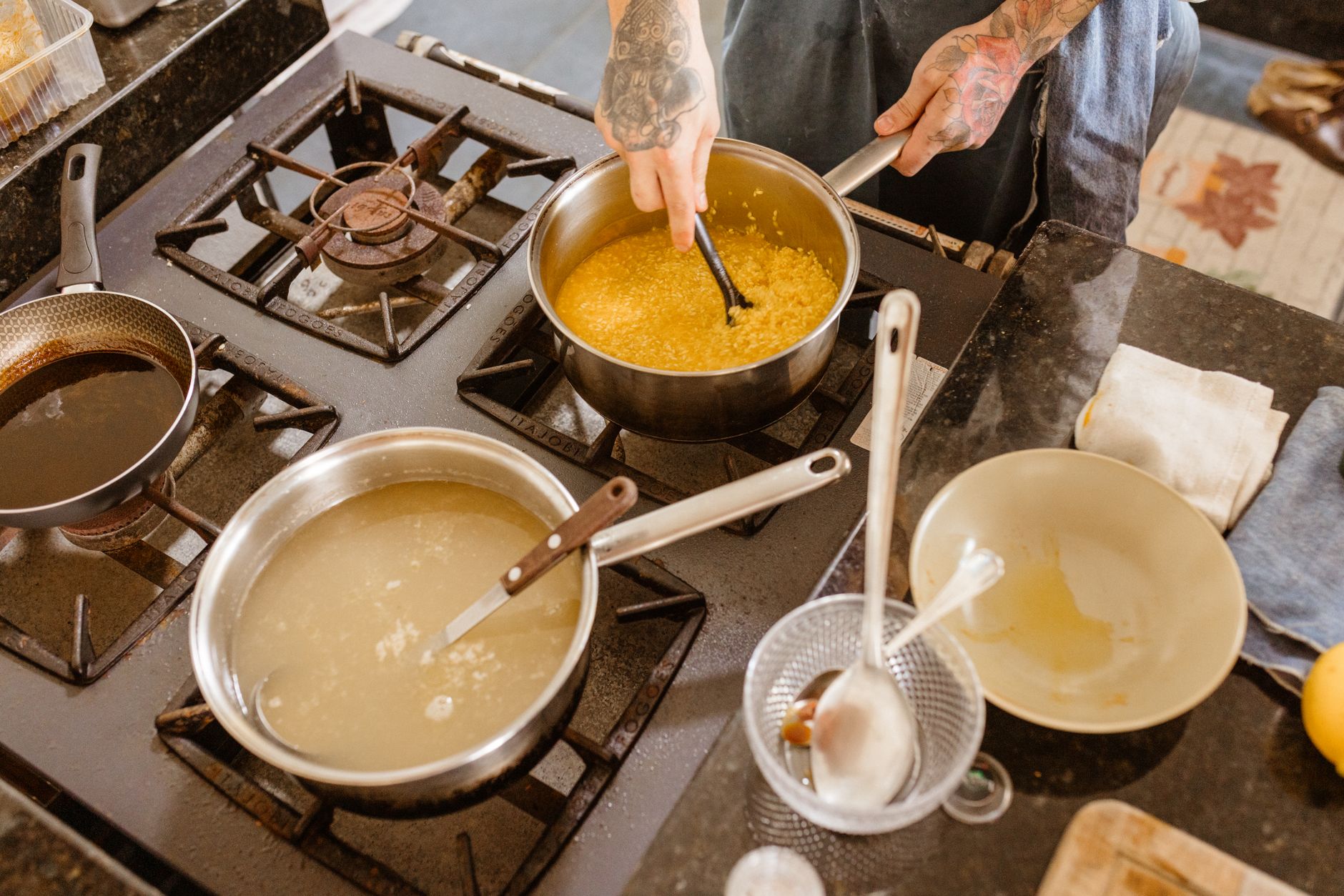 Nem tudo é simplesmente colocar no freezer: especialista explica como congelar alimentos sem comprometer sabor, textura e qualidade 3 Chef profissional mexendo ingredientes em um fogão a gás em um ambiente de cozinha moderna, demonstrando habilidade na preparação culinária.