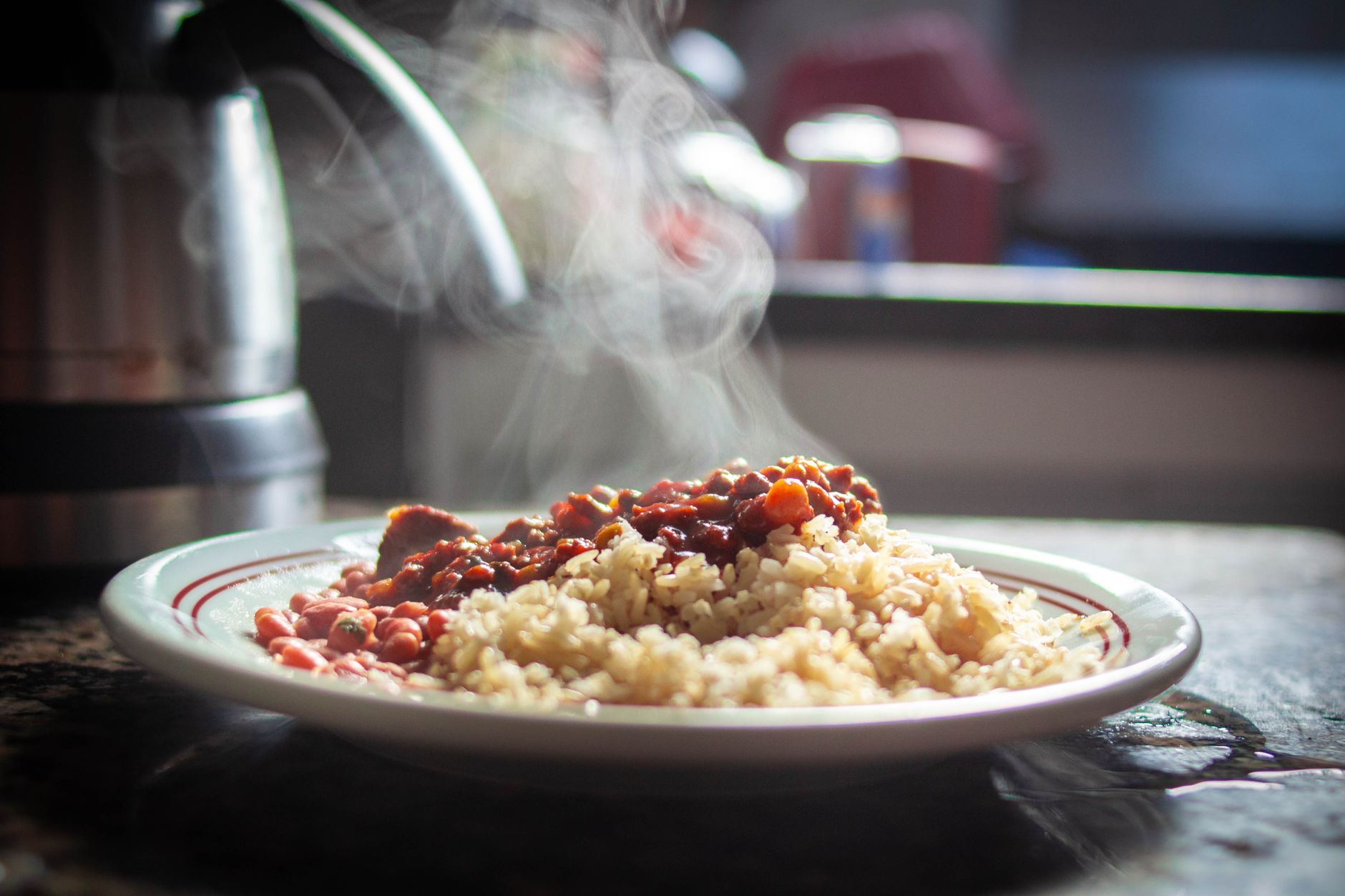 Nem tudo é simplesmente colocar no freezer: especialista explica como congelar alimentos sem comprometer sabor, textura e qualidade 9 Um close-up de arroz fumegante com feijão, capturado na luz morna da tarde.