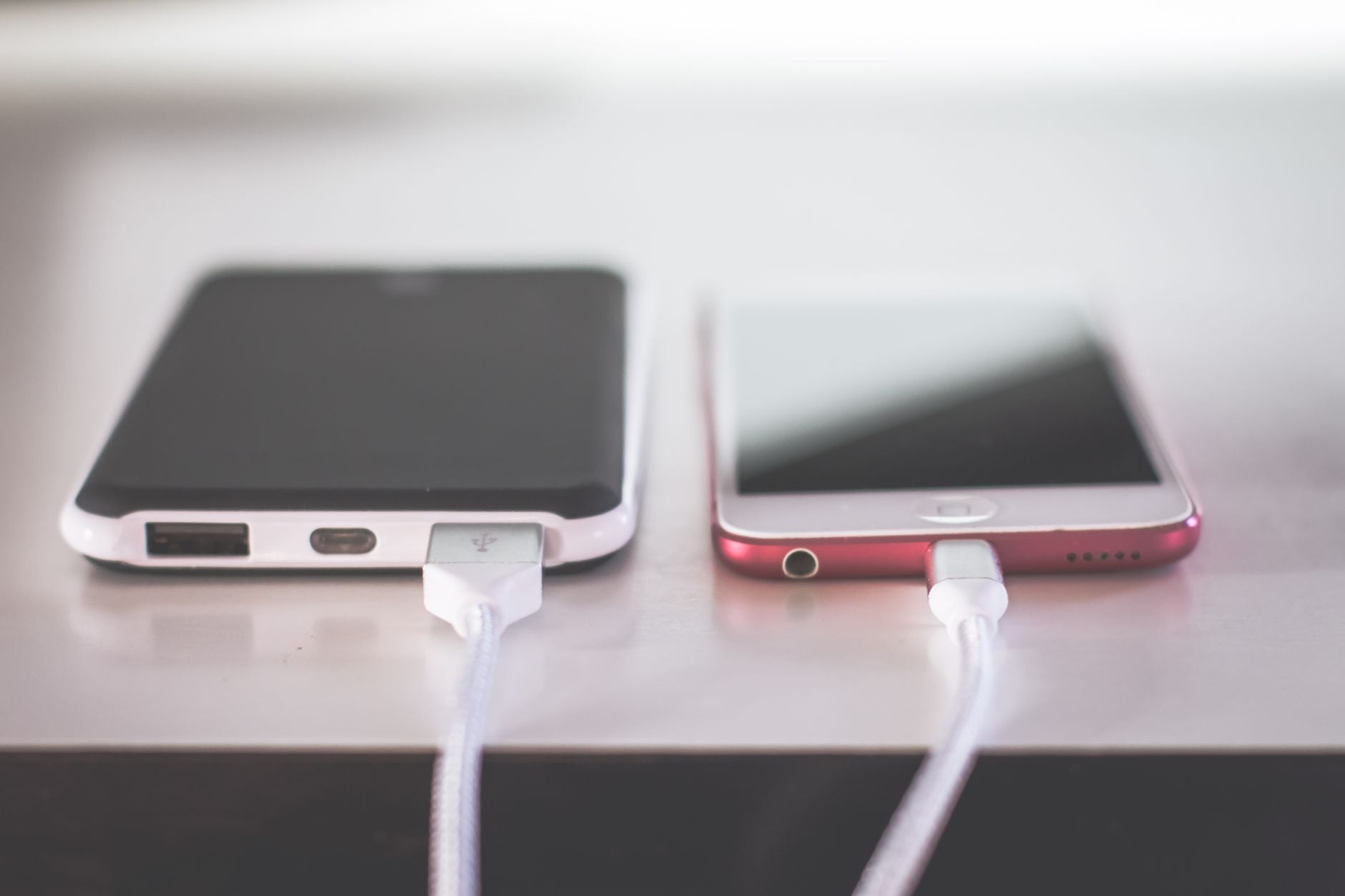 O jeito certo de deixar o celular na mesa pode ajudar a evitar distrações e esconder suas notificações de quem está por perto 3 Dois smartphones carregando lado a lado em uma mesa. Ambiente moderno e tecnológico.