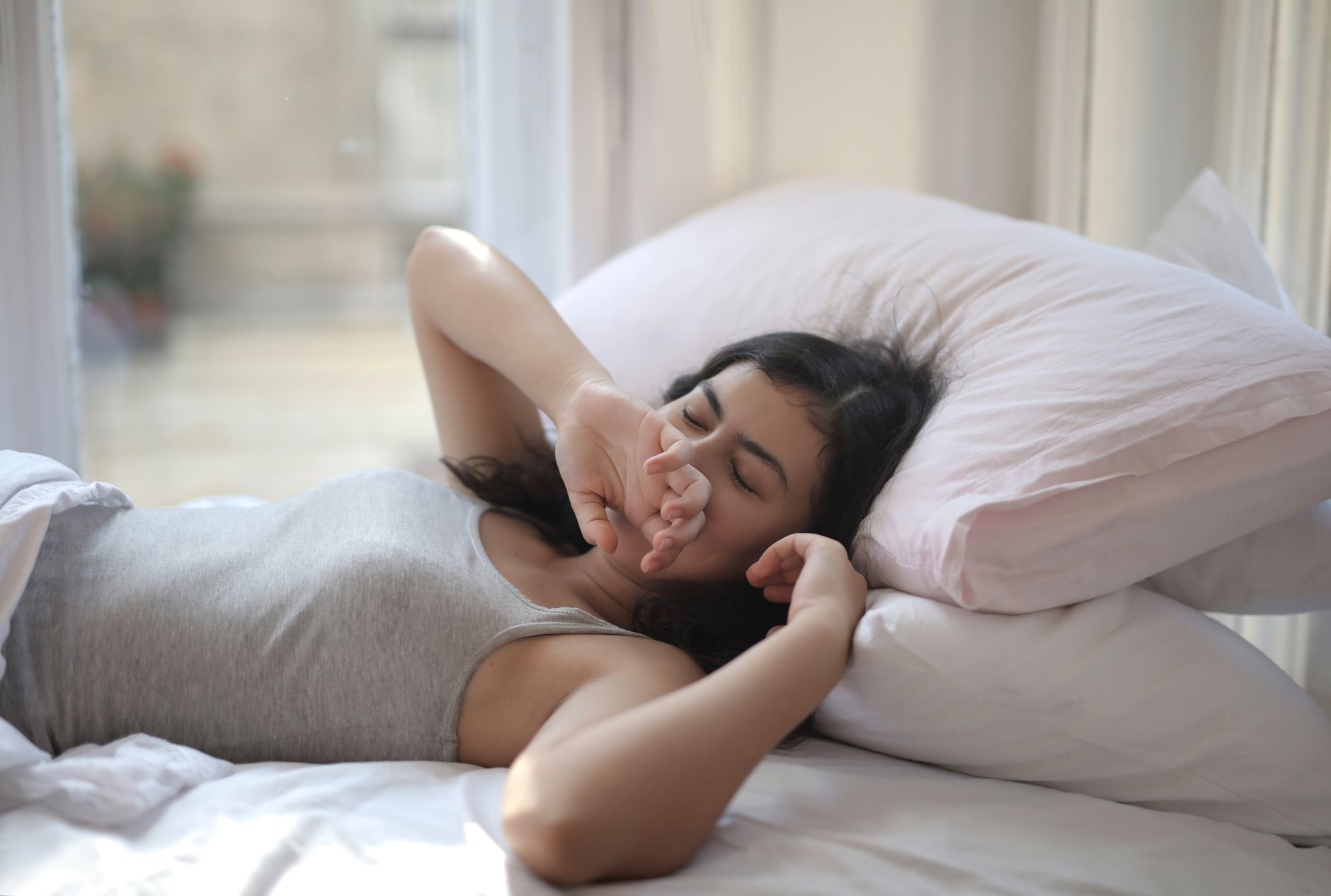 Por que algumas pessoas conversam, respondem e até gritam enquanto estão dormindo? Especialista explica o que pode estar por trás do comportamento 3 Uma mulher descansando confortavelmente em um cama aconchegante, perfeita para temas de estilo de vida ou relaxamento.
