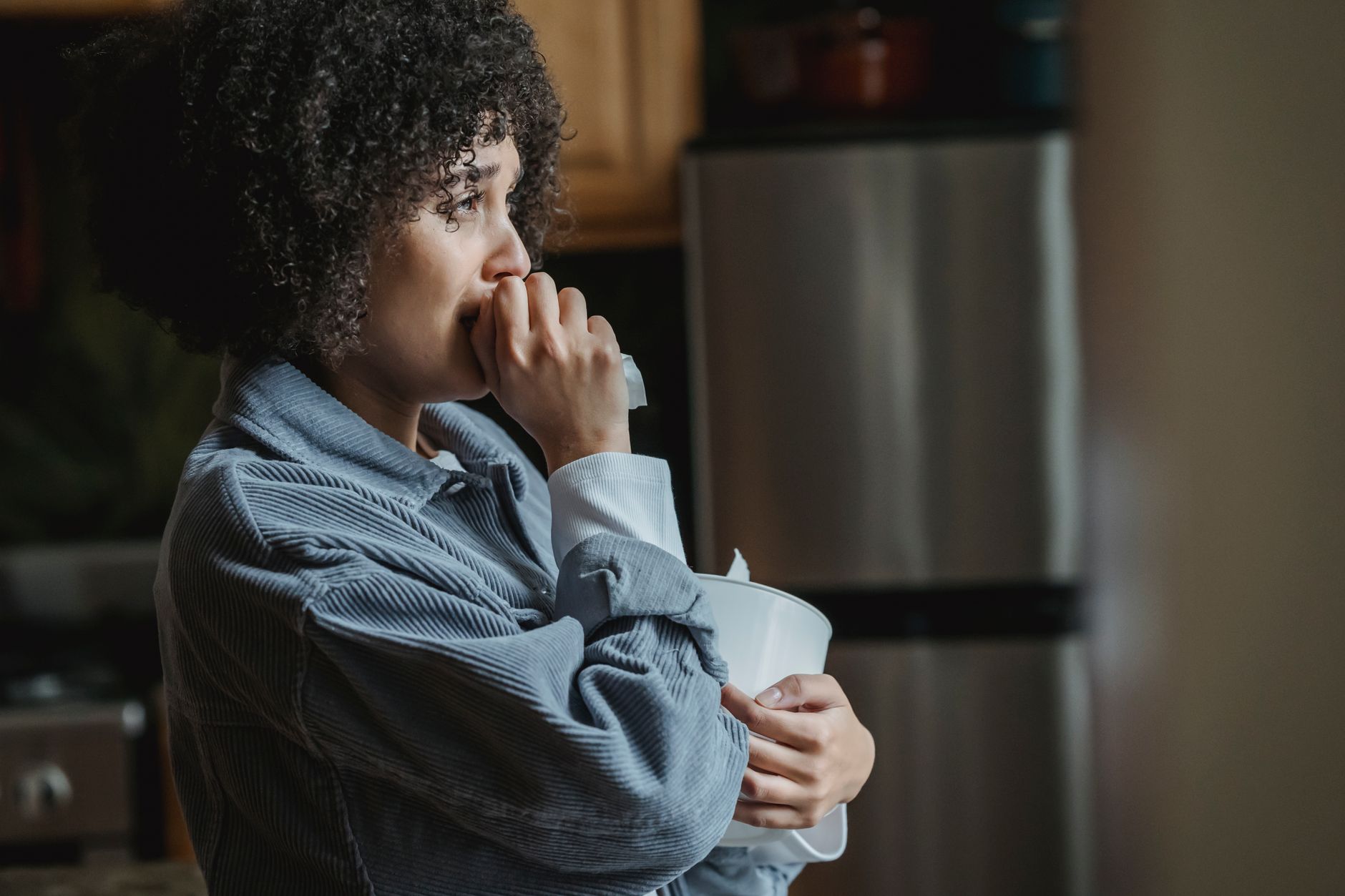 Você começa a chorar ao sentir o cheiro ou comer algo de que gosta? Síndrome rara faz o cérebro confundir os nervos da saliva com os das lágrimas 1 Uma jovem mulher emocionada está na sua cozinha segurando um lenço, imersa em pensamentos.