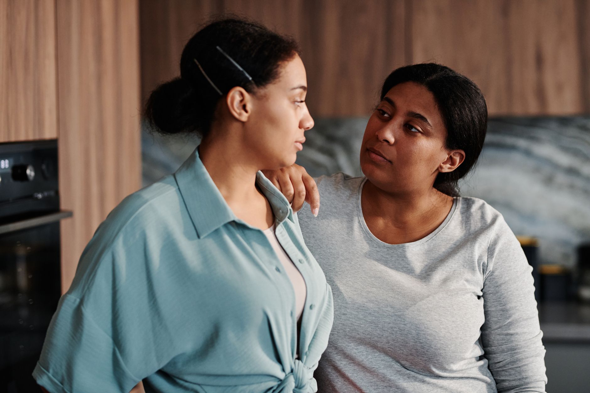 Você consegue admitir que pode estar errado? Psicologia aponta esse comportamento como uma das características de quem tem mente aberta, curiosidade e maior capacidade de aprender 1 Duas mulheres compartilhando um momento de apoio dentro de casa, destacando amizade e conexão.