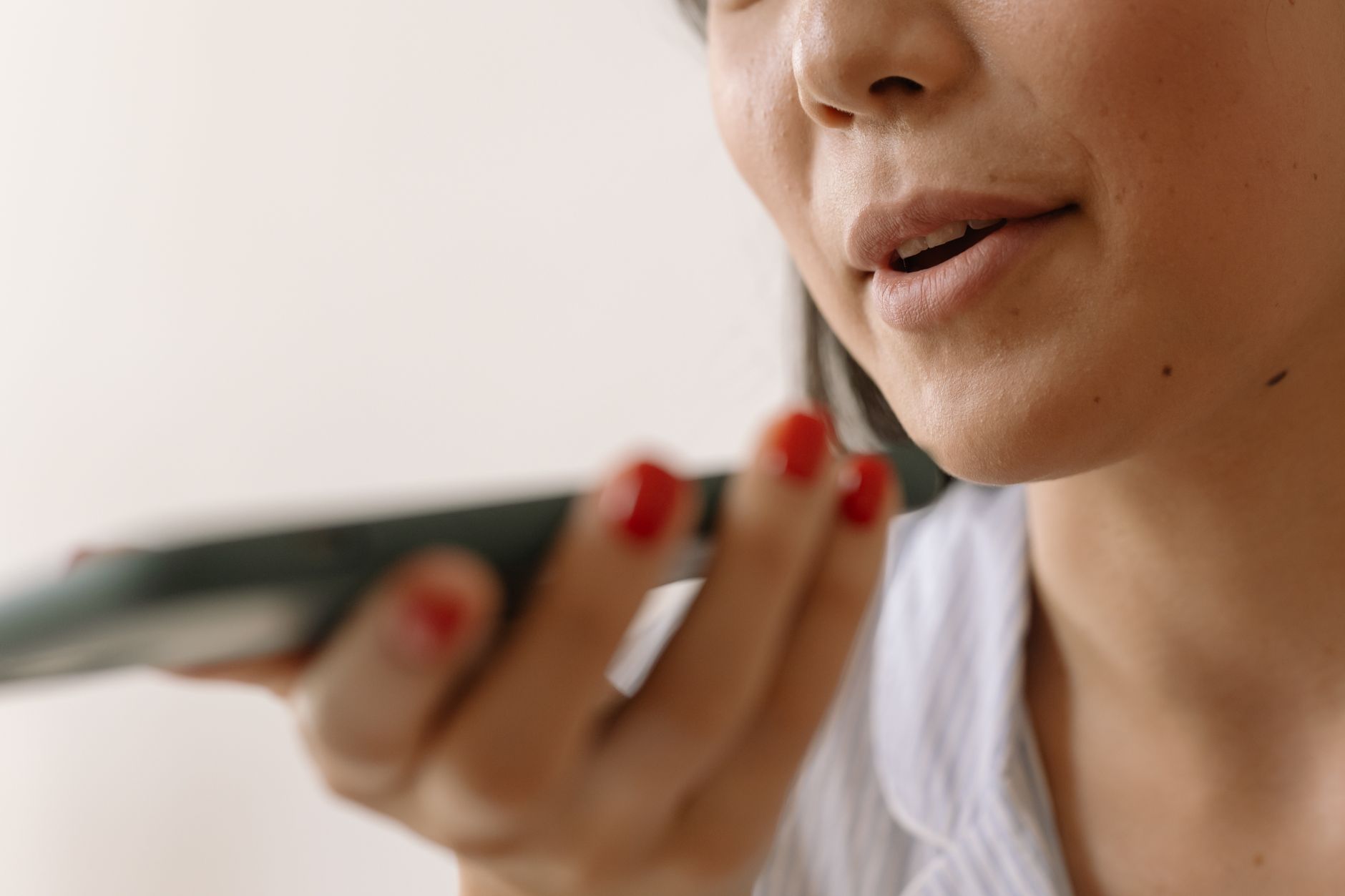 Você deixa o celular tocar e prefere não atender? Psicologia explica por que algumas pessoas ignoram ligações e o que esse comportamento pode revelar 1 Close-up de uma mulher usando comando de voz no smartphone, mostrando tecnologia e comunicação.