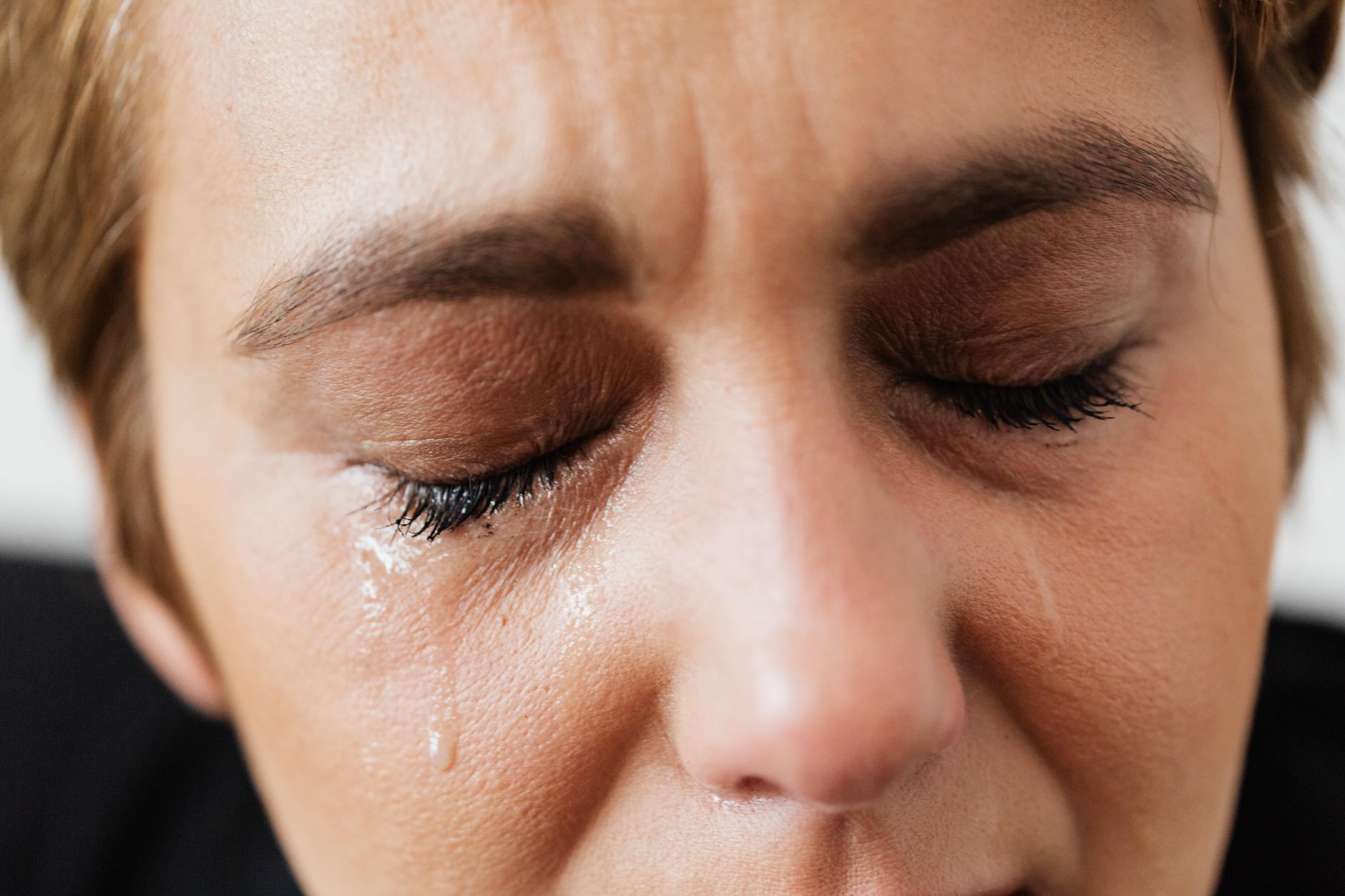 Você vive sozinho, pensa demais ou costuma falar sozinho? Esses 8 comportamentos podem parecer estranhos, mas são associados a pessoas com inteligência acima da média 2 Close-up emocional do rosto de uma mulher com os olhos fechados e lágrimas que expressam angústia.