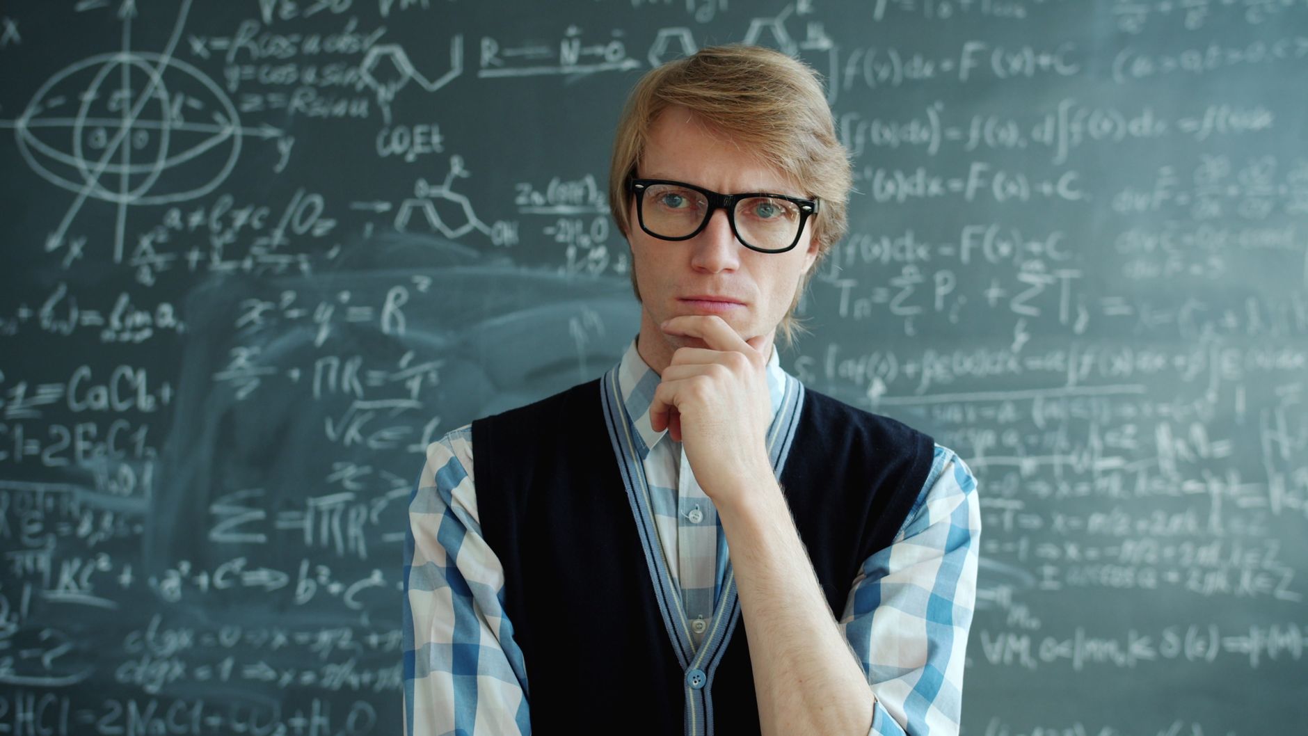 Você vive sozinho, pensa demais ou costuma falar sozinho? Esses 8 comportamentos podem parecer estranhos, mas são associados a pessoas com inteligência acima da média 4 Professora pensativa ponderando equações matemáticas complexas no quadro-negro.
