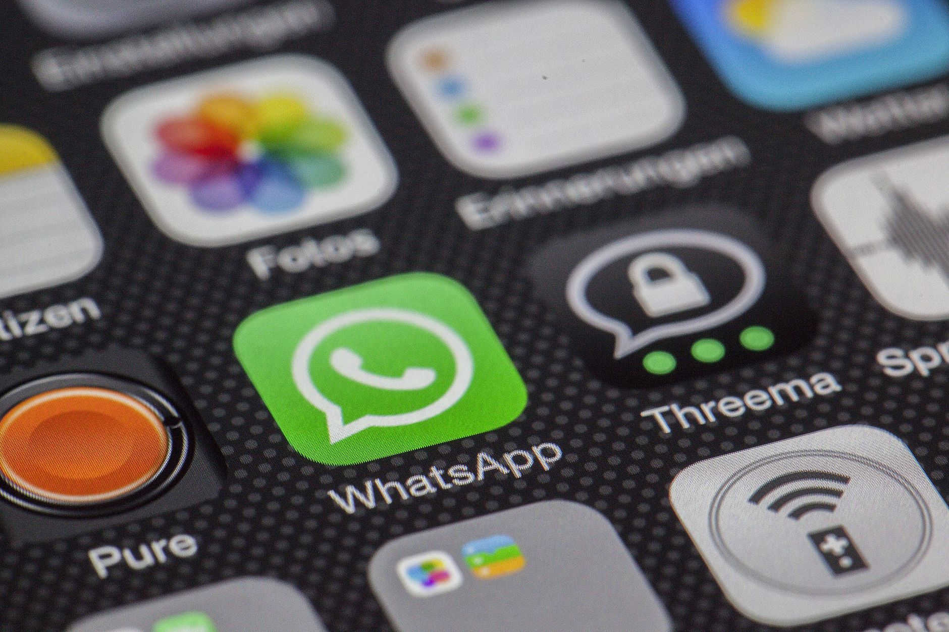 Macro detalhada da tela do smartphone exibindo ícones de aplicativos populares como WhatsApp.