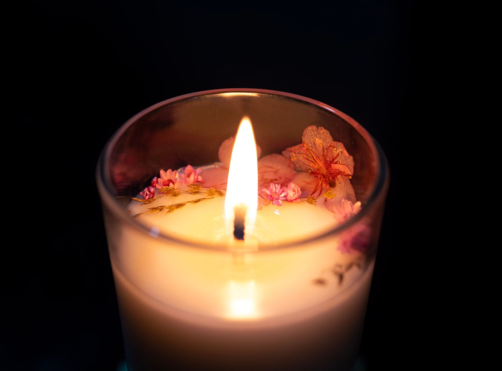 Depois da festa, muita gente simplesmente vai embora, mas especialistas revelam o gesto esquecido que pode fazer o anfitrião lembrar de você de uma forma especial 2 Uma vela artesanal lindamente iluminada, adornada com flores de cerejeira, proporciona um ambiente acolhedor e aconchegante.