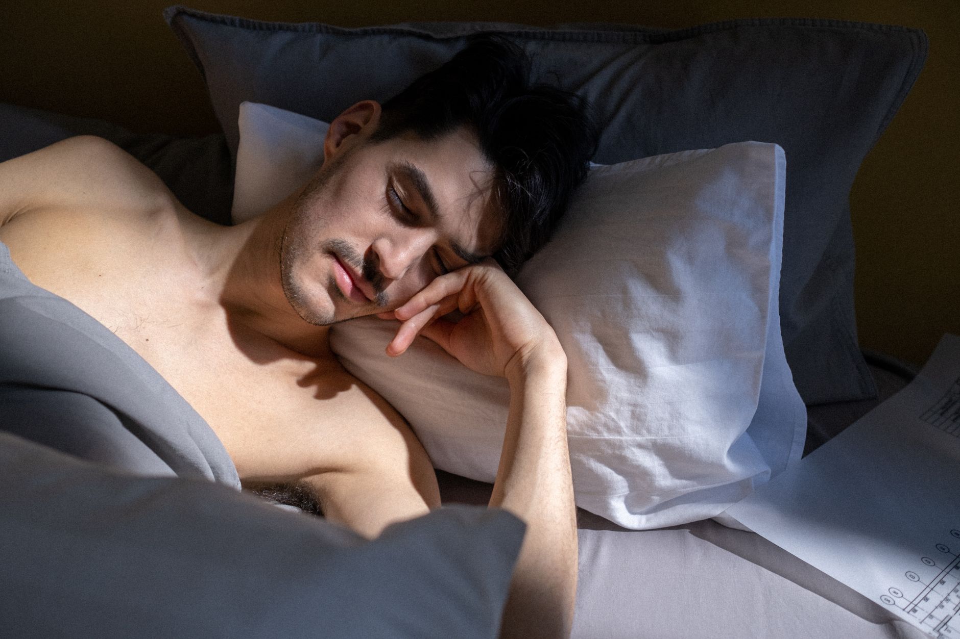 Ele passou anos estudando por que as pessoas dormem mal e descobriu que mudanças simples na rotina podem fazer diferença, incluindo um hábito que muita gente faz antes de deitar 1 Um homem dormindo pacificamente em um quarto iluminado pelo sol com luz natural entrando.