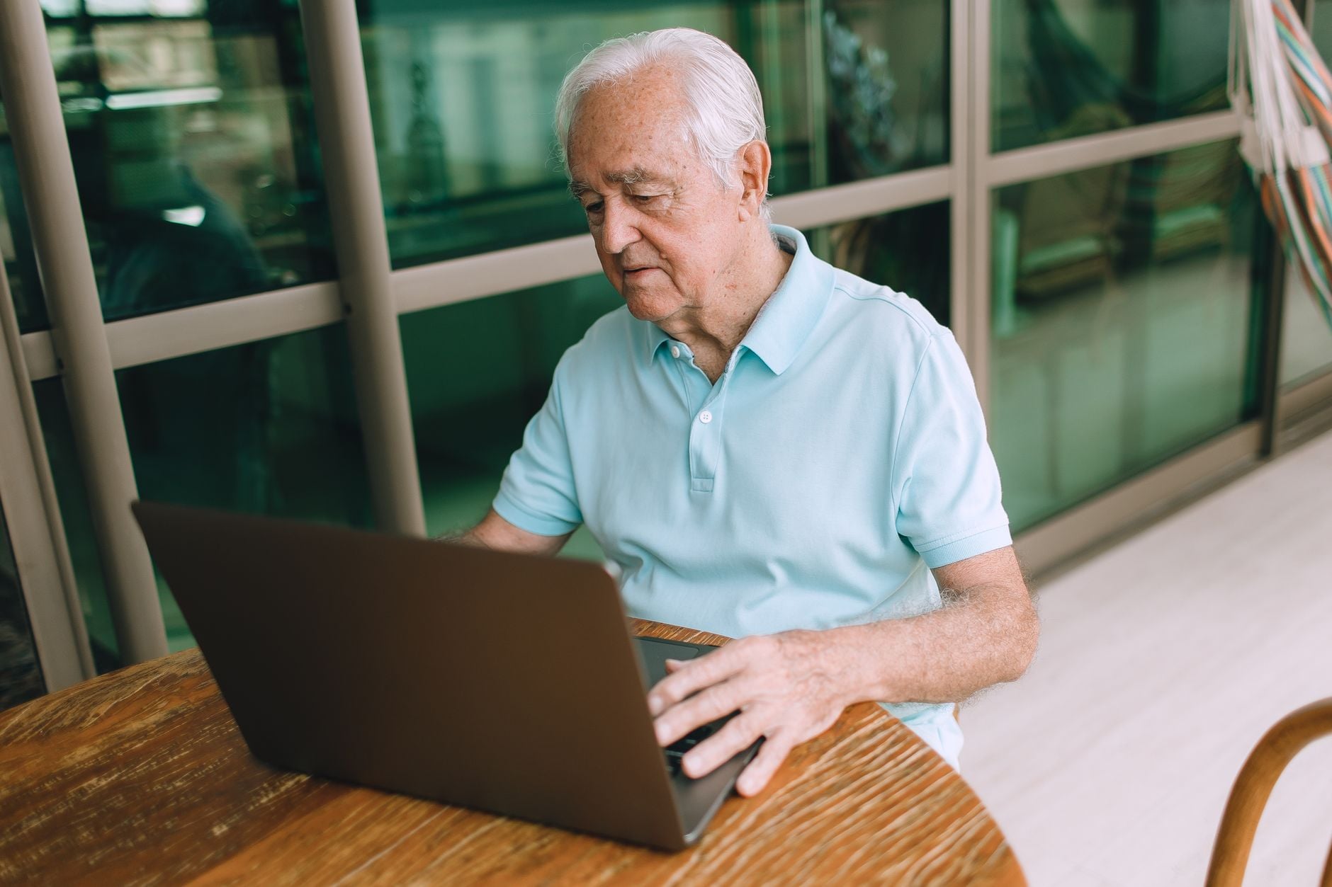 Eles não são contra a tecnologia e nem estão presos ao passado: pessoas criadas nos anos 60, 70 e 80 apenas lembram de quando as coisas funcionavam de outra maneira e por isso se recusam a aceitar mudanças que hoje parecem normais 4 Um homem idoso concentrado no uso de um laptop dentro de casa, destacando tecnologia e conectividade.