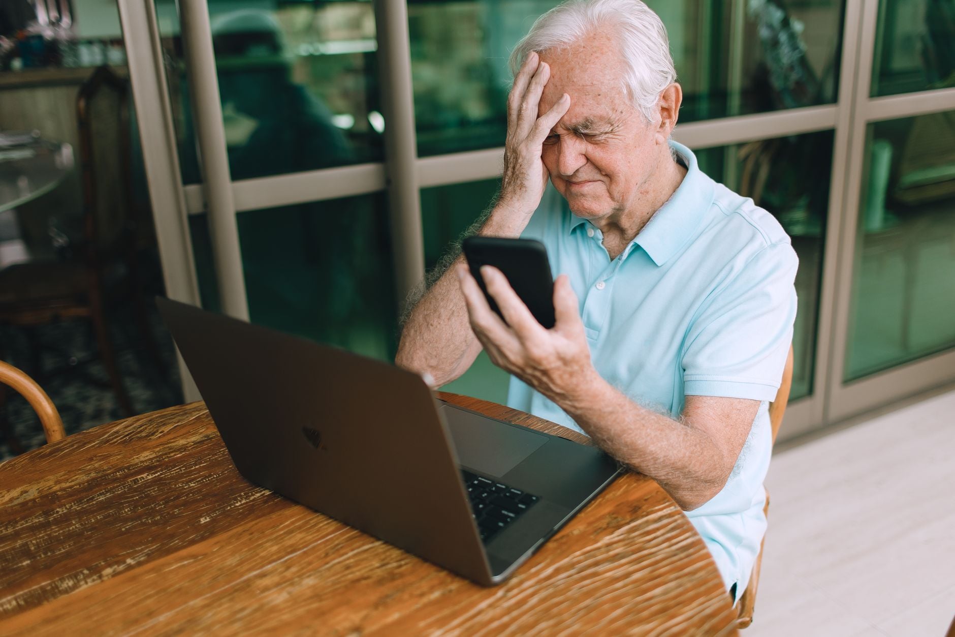 Eles não são contra a tecnologia e nem estão presos ao passado: pessoas criadas nos anos 60, 70 e 80 apenas lembram de quando as coisas funcionavam de outra maneira e por isso se recusam a aceitar mudanças que hoje parecem normais 8 Homem idoso frustrado com a tecnologia de smartphone e laptop dentro de casa.