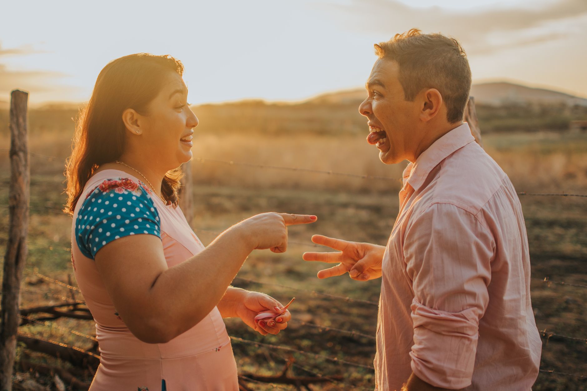 Em vez de insistir que a outra pessoa está errada, especialista recomenda duas etapas para conversar com quem nunca reconhece os próprios erros 5 Dois adultos desfrutando de um momento divertido ao ar livre ao pôr do sol, irradiando alegria e conexão.