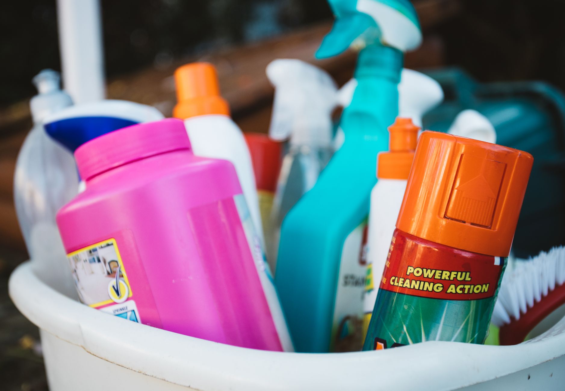 Faxina antes do Natal: a ordem certa para limpar a casa em um dia sem se cansar 3 Close-up de diversos produtos de limpeza em um balde ao ar livre, exibindo vários detergentes e sprays.