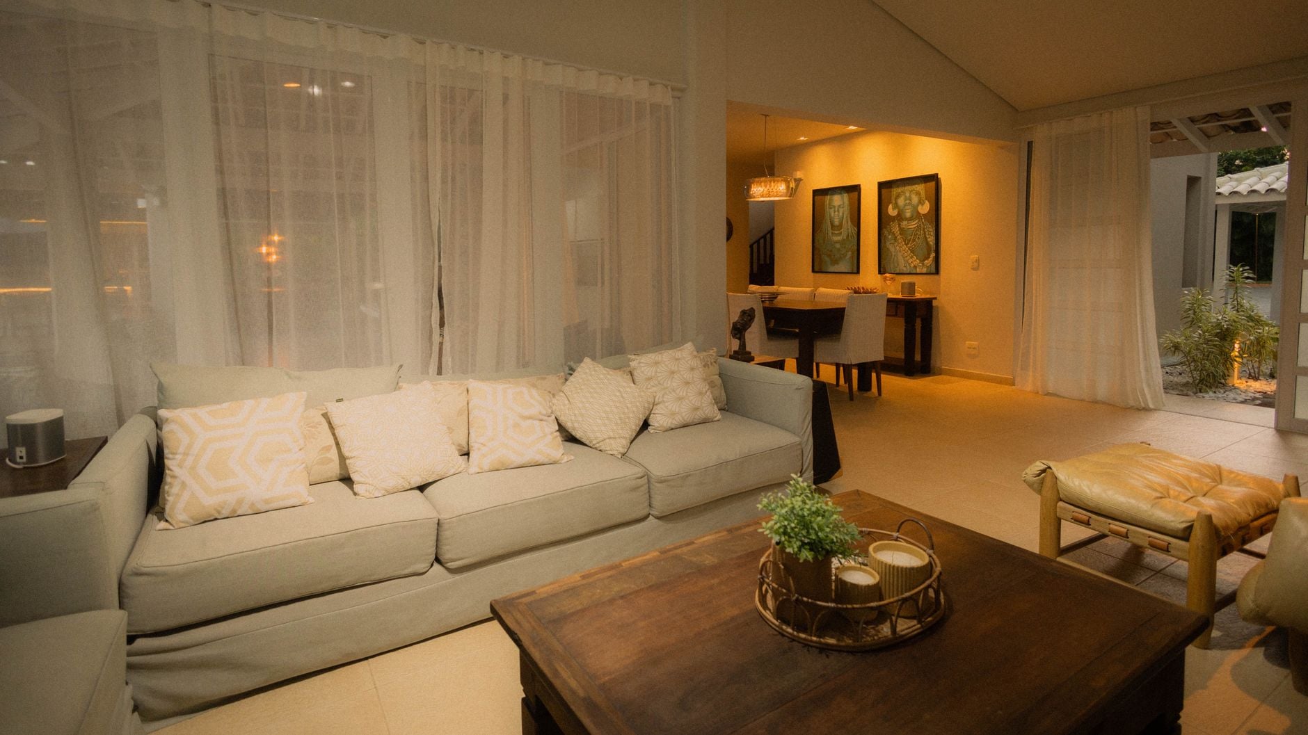 Faxina antes do Natal: a ordem certa para limpar a casa em um dia sem se cansar 5 Sala de estar moderna e convidativa, com cores neutras, mobiliário elegante e iluminação ambiente.