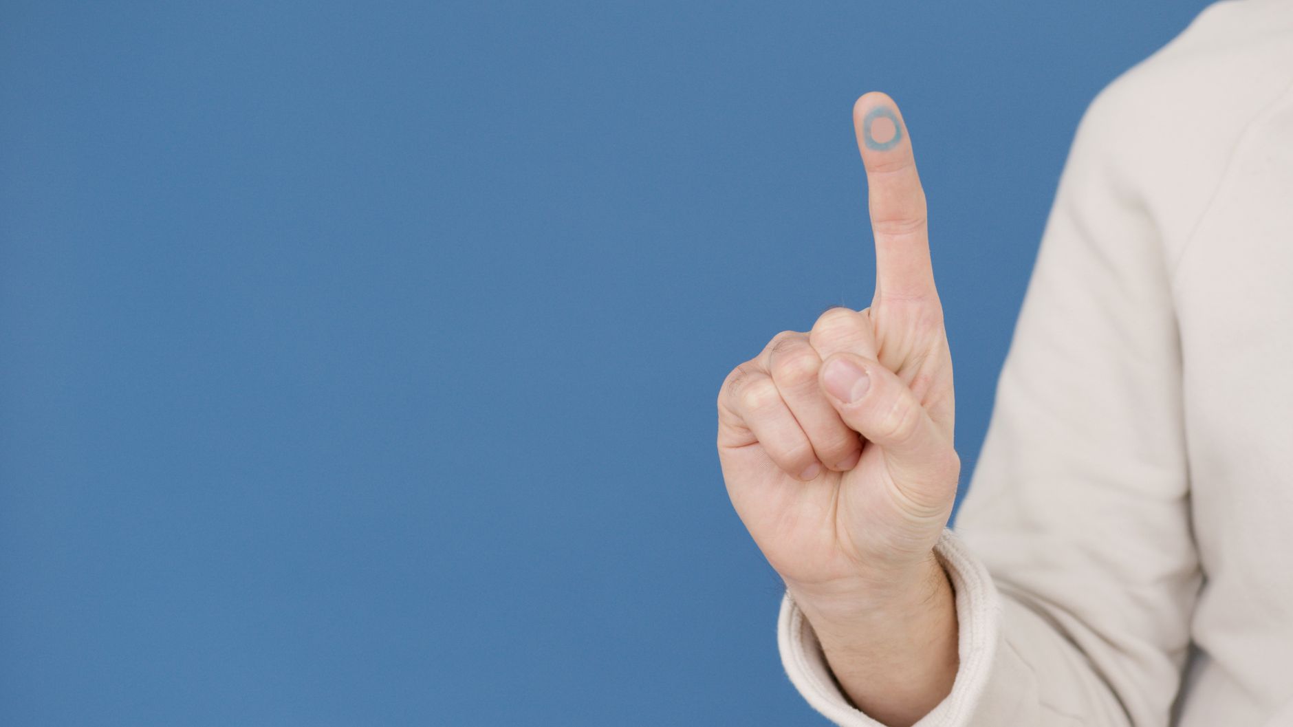 Não fiz a biometria: posso votar mesmo assim? 1 Um gesto com a mão simbolizando a conscientização sobre diabetes com um círculo azul sobre um fundo azul.