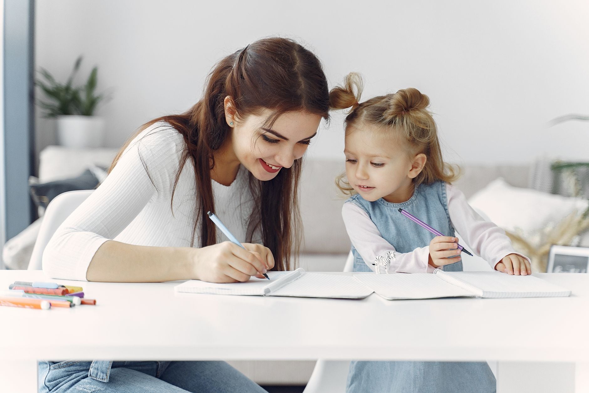 Uma mãe e filha desfrutam de um momento de conexão enquanto fazem o dever de casa juntas, em casa.