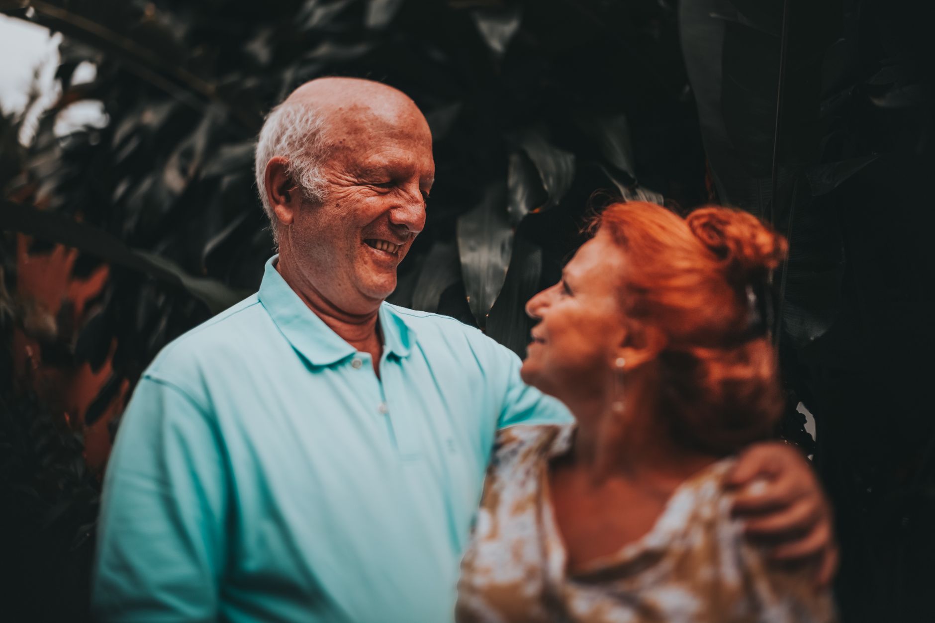 O tempo passa para todo mundo, mas o envelhecimento não acontece da mesma maneira e hábitos mantidos durante anos podem fazer uma pessoa envelhecer de forma muito diferente de outra que tem exatamente a mesma idade 1 Casal idoso sorrindo e se abraçando em um ambiente externo verdejante, capturando amor e amizade.