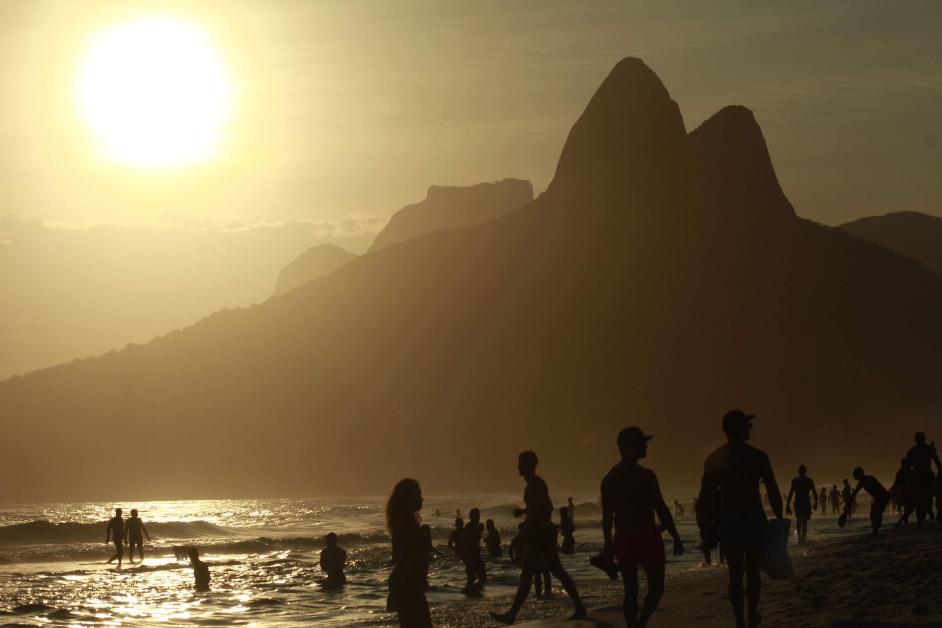 Próximo presidente do Brasil terá pela frente um problema que já afeta milhões de pessoas e pode se tornar ainda mais grave nos próximos anos 1 Silhuetas de pessoas aproveitando a praia ao pôr do sol com as icônicas montanhas do Rio ao fundo.
