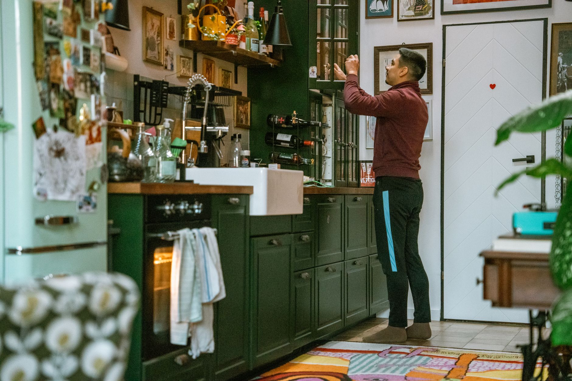Quando os pais colocam responsabilidades de adultos sobre os filhos ainda pequenos, algumas crianças aprendem a cuidar de todo mundo menos delas mesmas e levam esse comportamento para a vida adulta 4 Um homem organiza itens em uma cozinha elegante com armários verdes e decoração para casa.