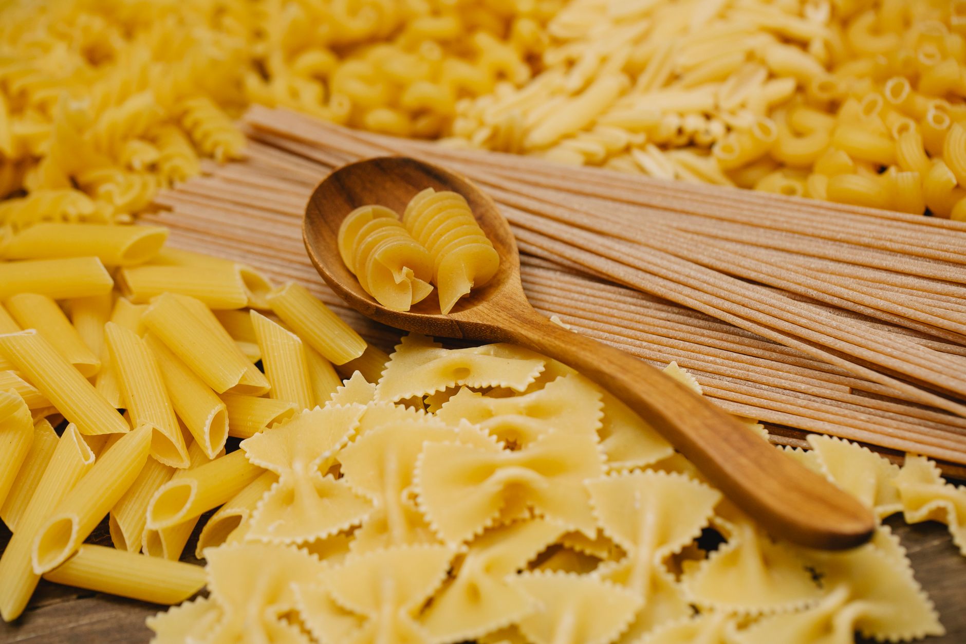 Segundo chefs italianos, este é o único tipo de massa que vale a pena comprar no supermercado 1 Uma seleção de massas italianas cruas, incluindo penne, farfalle e rotini, em uma colher de madeira.