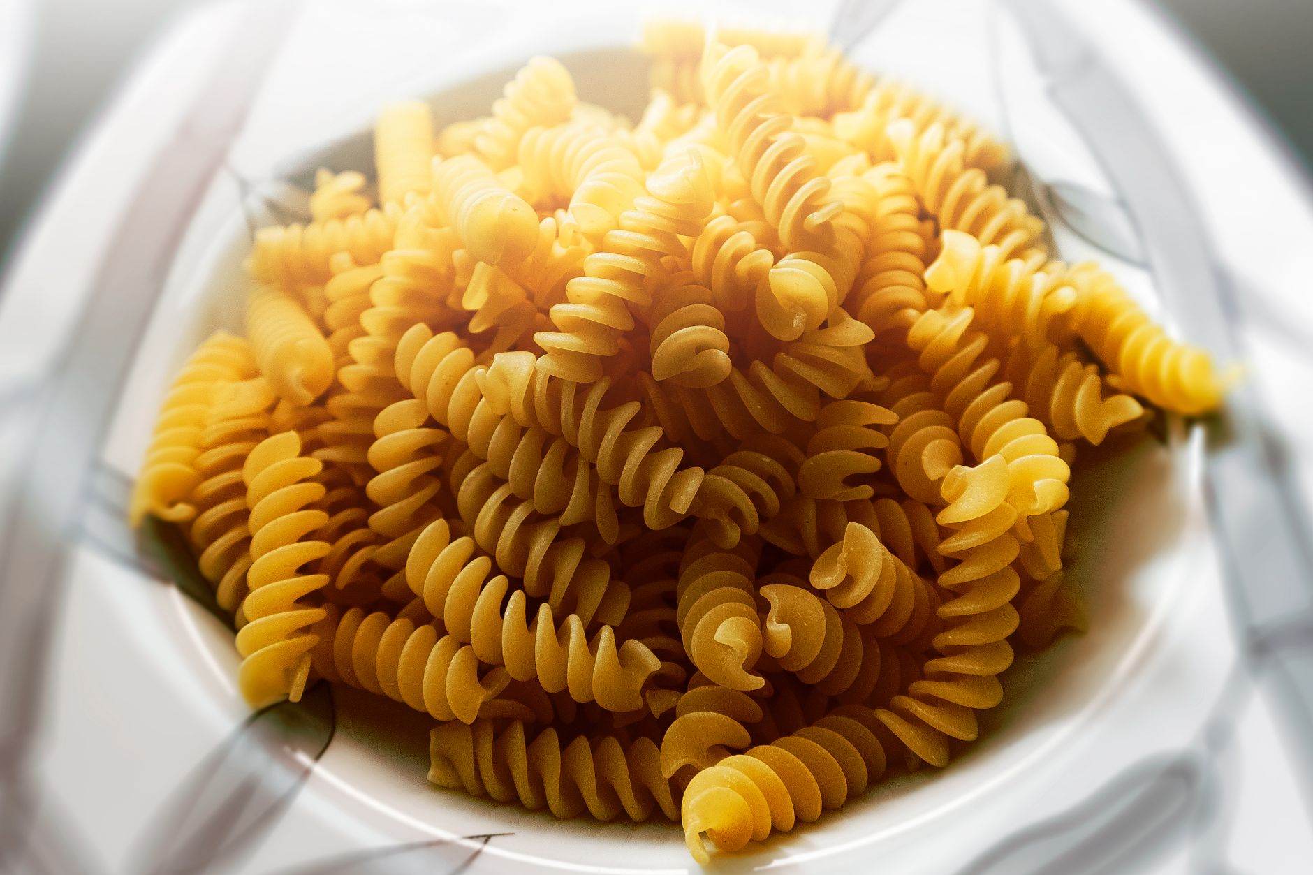 Segundo chefs italianos, este é o único tipo de massa que vale a pena comprar no supermercado 2 Close-up de fusilli cru em uma tigela branca, perfeito para a culinária italiana.