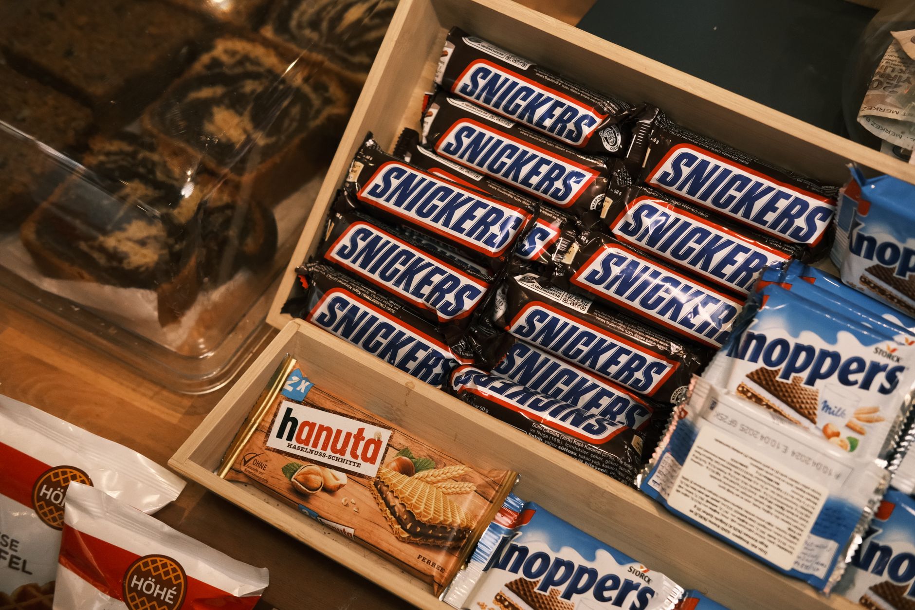 Uma nova estratégia para fazer compras no supermercado usa apenas os números 5-4-3-2-1 e pode ajudar quem costuma gastar mais do que deveria ou comprar alimentos demais 5 Uma variedade de lanches de chocolate e wafer, incluindo Snickers e Hanuta, em uma caixa de madeira.