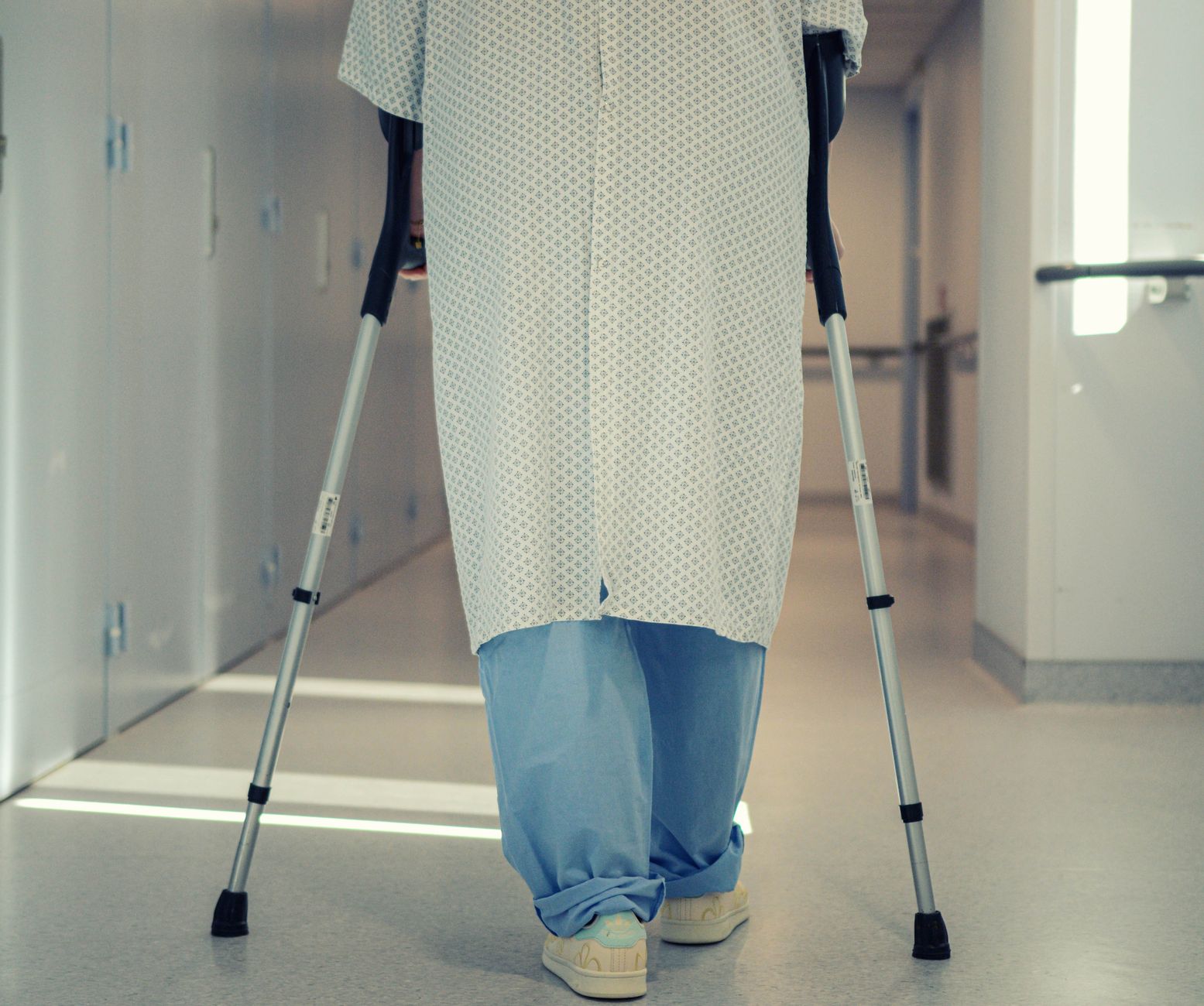 Uma simples goteira acabou causando um problema inesperado e homem que sofreu as consequências levou o caso à Justiça e conseguiu receber indenização 1 Um paciente idoso usando muletas para caminhar por um corredor de hospital, simbolizando recuperação e assistência à mobilidade.