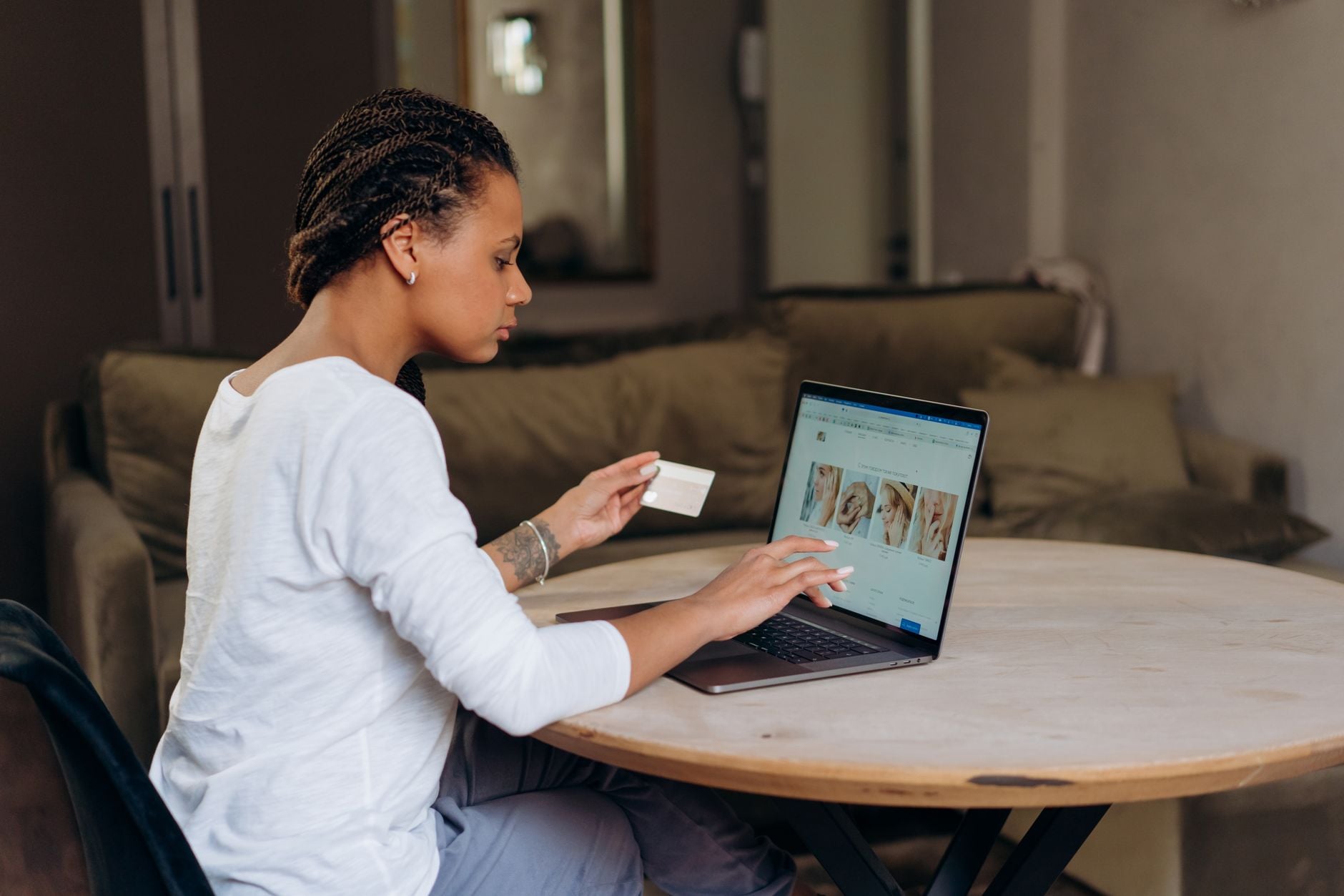 Você comprou roupas pela internet nos últimos dias? Ataque a lojas brasileiras capturava cartões e CPFs durante o pagamento 3 Mulher afro-americana usa um cartão de crédito para uma compra online em seu laptop em casa.